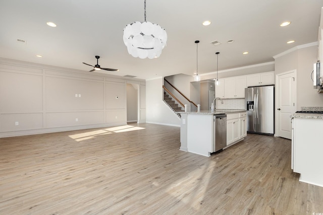 kitchen featuring white cabinetry, pendant lighting, and appliances with stainless steel finishes