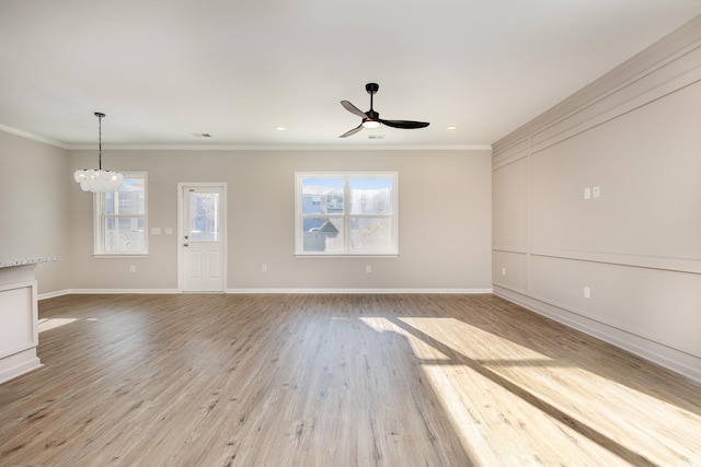 unfurnished living room with ornamental molding, ceiling fan with notable chandelier, and light hardwood / wood-style flooring