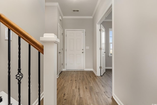 entryway featuring ornamental molding and light wood-type flooring