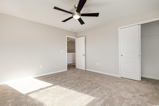 unfurnished bedroom featuring light colored carpet, ceiling fan, and a closet