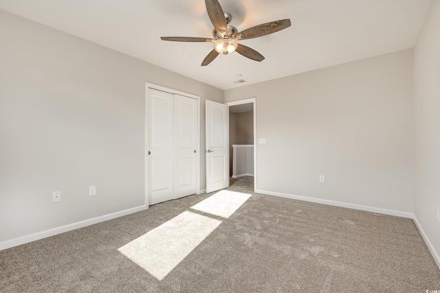 unfurnished bedroom with a closet, ceiling fan, and carpet flooring