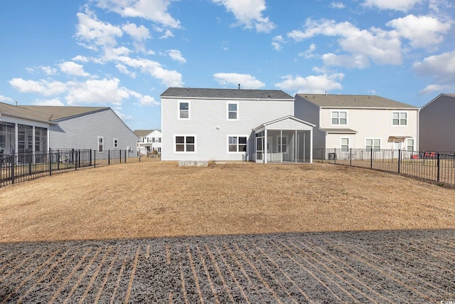 rear view of property with a sunroom and a yard