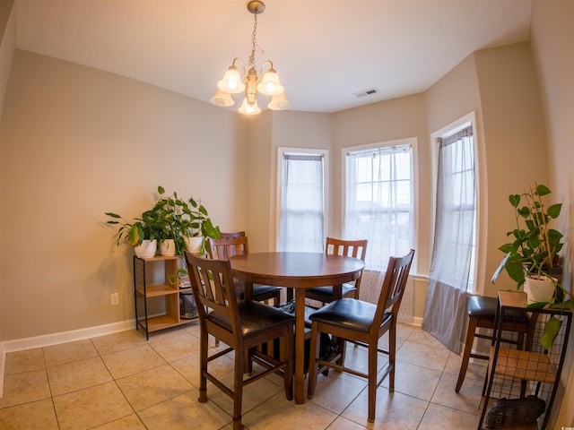 tiled dining room with an inviting chandelier