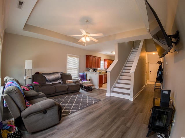 788 Rambler Ct, Myrtle Beach, SC 29588 - living area featuring stairway, dark wood-type flooring, a ceiling fan, a wood stove, and a raised ceiling