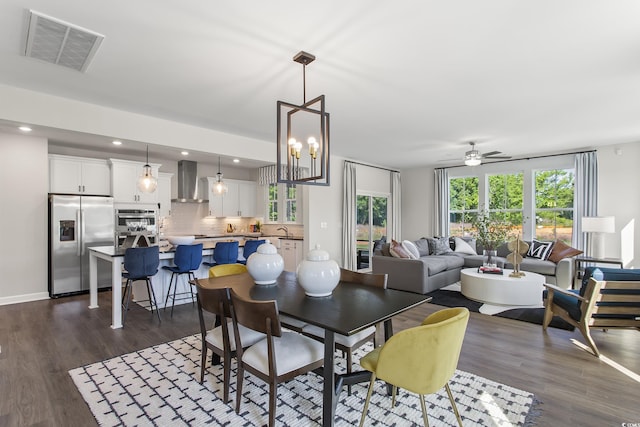 dining space with dark wood-type flooring, ceiling fan, and sink