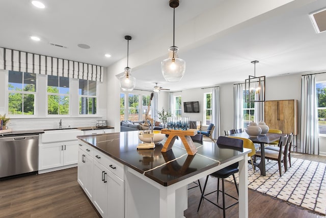 kitchen with sink, white cabinetry, decorative light fixtures, dark hardwood / wood-style flooring, and dishwasher