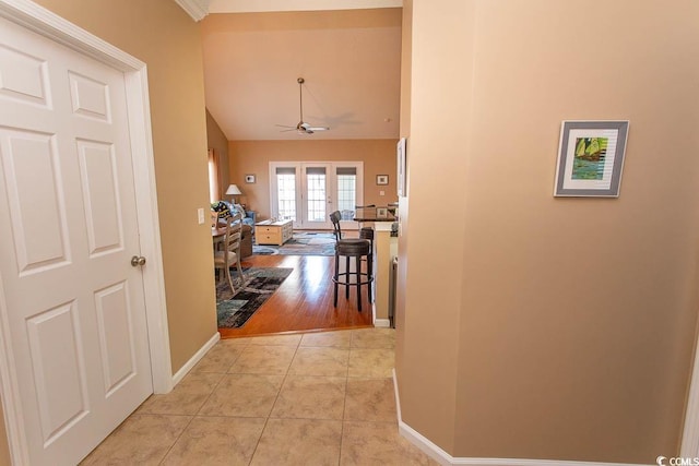 hallway featuring french doors, lofted ceiling, and light tile patterned floors