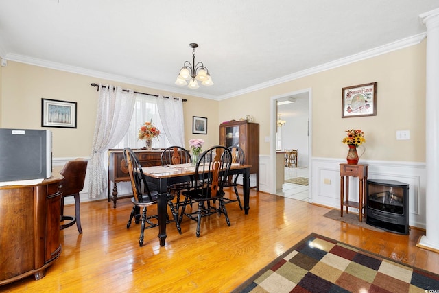 dining space featuring crown molding, light hardwood / wood-style flooring, and a notable chandelier