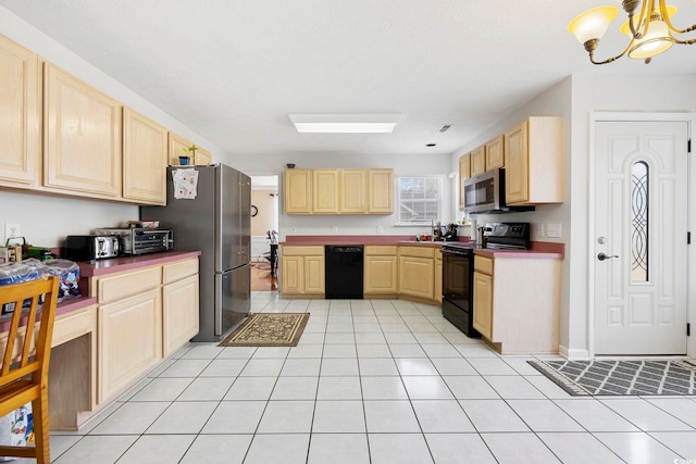 kitchen with a chandelier, light tile patterned floors, light brown cabinets, and black appliances