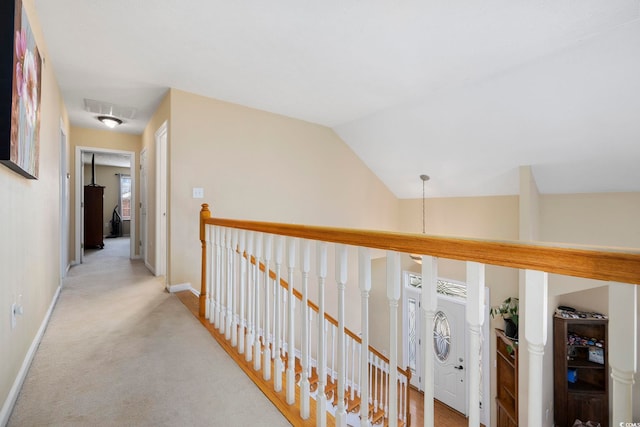 hallway featuring light carpet and vaulted ceiling