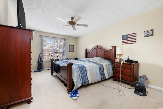 carpeted bedroom featuring ceiling fan and a textured ceiling