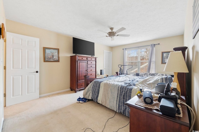 carpeted bedroom featuring ceiling fan and a textured ceiling