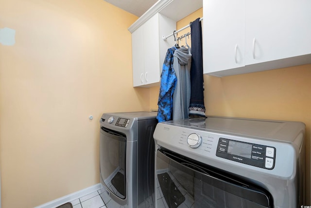 washroom featuring cabinets, washer and dryer, and light tile patterned floors