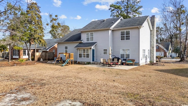 back of house featuring a playground and a patio area