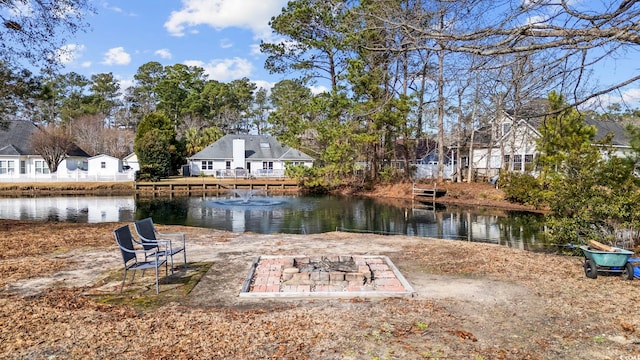 view of yard with a water view and an outdoor fire pit