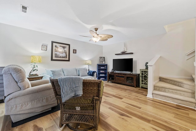 living room featuring wood-type flooring and ceiling fan