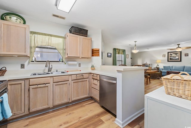 kitchen featuring dishwasher, sink, light brown cabinetry, and kitchen peninsula