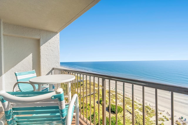 balcony featuring a view of the beach and a water view