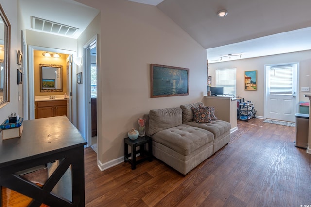 living room with dark wood-style floors, baseboards, visible vents, and vaulted ceiling