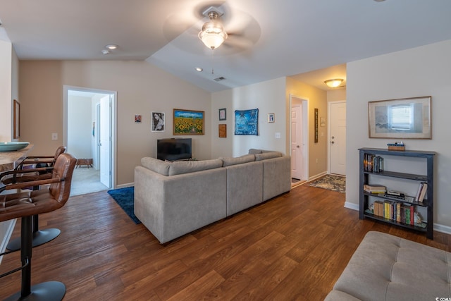 living area with dark wood-style flooring, vaulted ceiling, baseboards, and ceiling fan