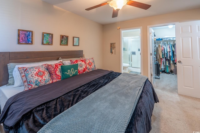 bedroom with a walk in closet, ensuite bath, light carpet, a closet, and ceiling fan