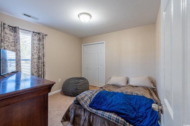 bedroom featuring light carpet, a closet, visible vents, and baseboards