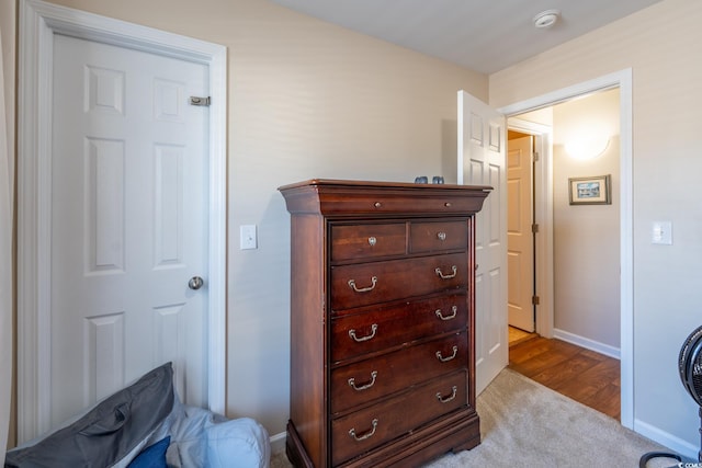 bedroom featuring light carpet and baseboards