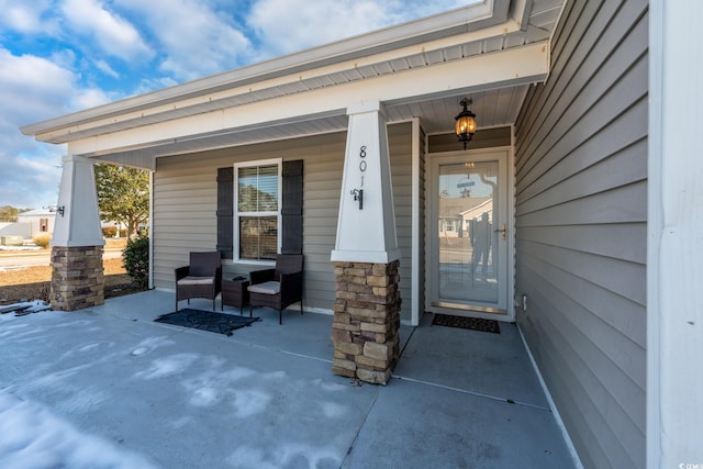 view of exterior entry featuring covered porch