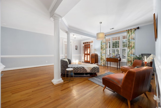 interior space with light wood-type flooring, ornamental molding, and ornate columns