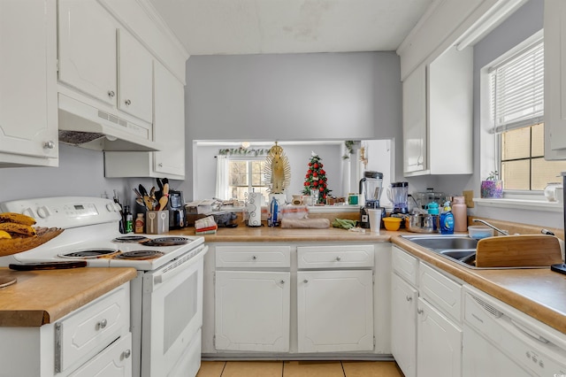 kitchen with white cabinetry, sink, light tile patterned floors, and white appliances