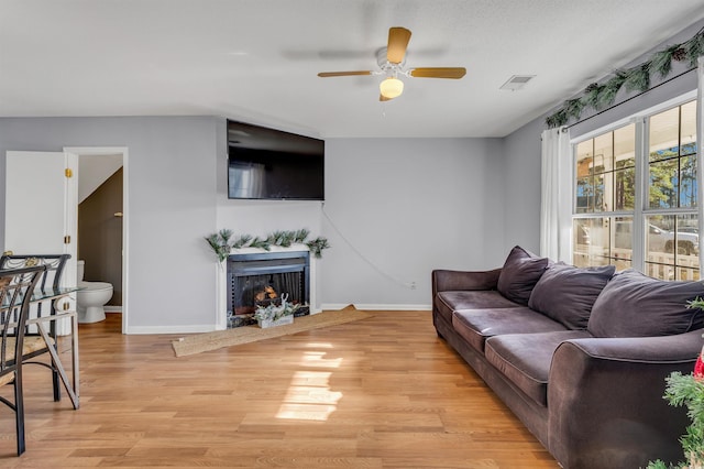 living room featuring ceiling fan and light hardwood / wood-style floors