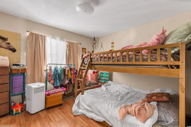 bedroom with a textured ceiling and light wood-type flooring