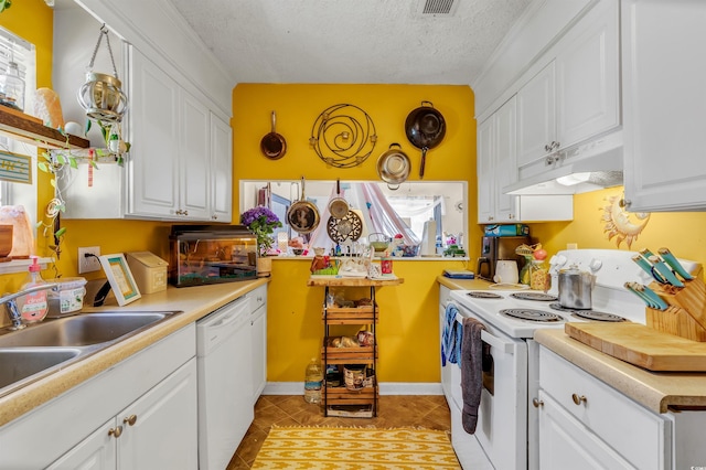 kitchen with white appliances, light tile patterned floors, a textured ceiling, and white cabinets