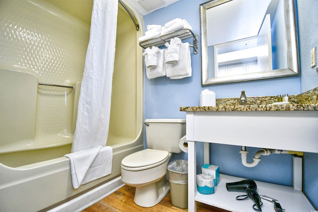 bathroom featuring hardwood / wood-style flooring, toilet, and shower / bath combination with curtain