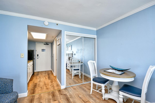 dining space featuring ornamental molding and light wood-type flooring