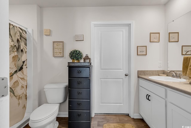 bathroom with hardwood / wood-style flooring, vanity, a shower with curtain, and toilet