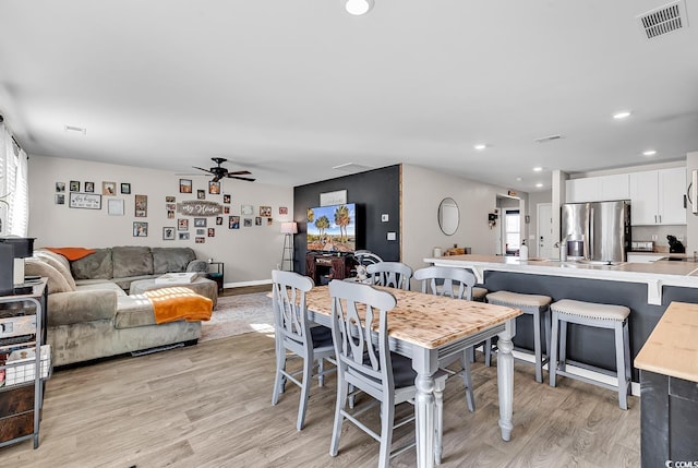 dining area featuring ceiling fan and light wood-type flooring