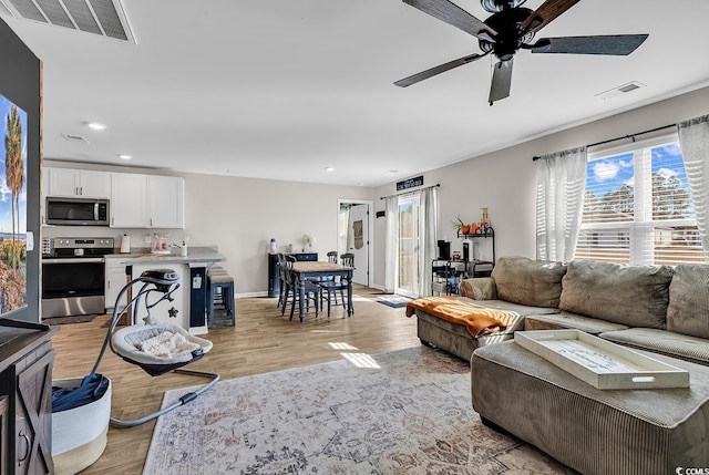 living room with ceiling fan and light hardwood / wood-style floors