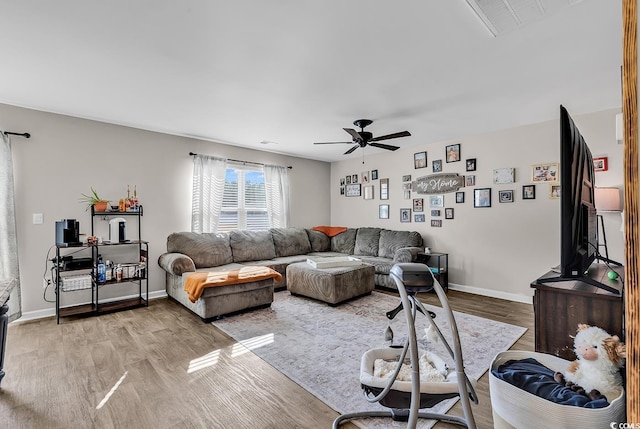 living room featuring ceiling fan and light hardwood / wood-style flooring