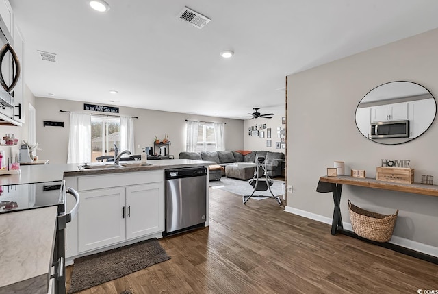 kitchen with white cabinetry, sink, ceiling fan, stainless steel appliances, and dark wood-type flooring