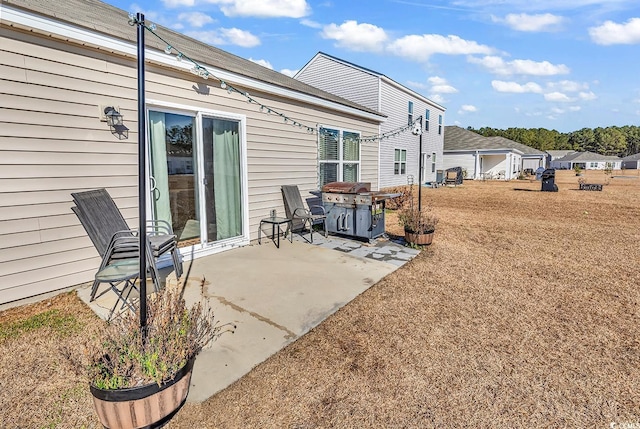 rear view of house featuring a lawn and a patio