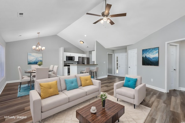 living room featuring ceiling fan with notable chandelier, vaulted ceiling, and wood-type flooring