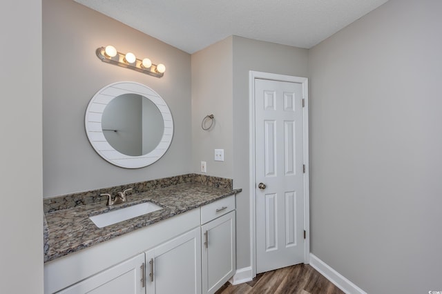 bathroom featuring vanity, wood-type flooring, and a textured ceiling