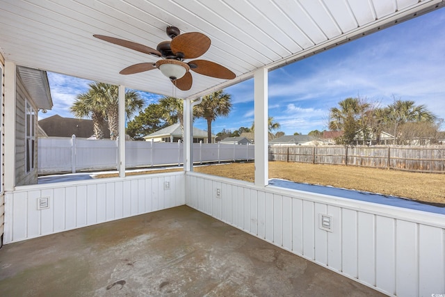 unfurnished sunroom featuring ceiling fan