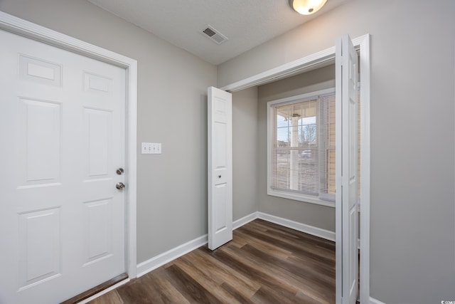 foyer featuring dark hardwood / wood-style floors and a textured ceiling