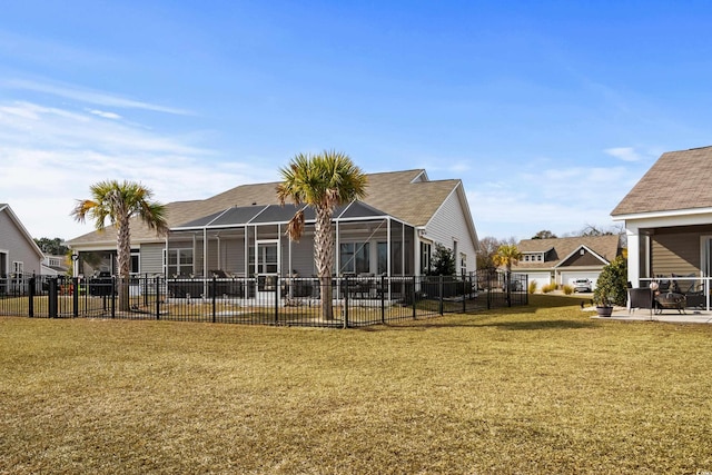 back of property with a patio, glass enclosure, and a lawn