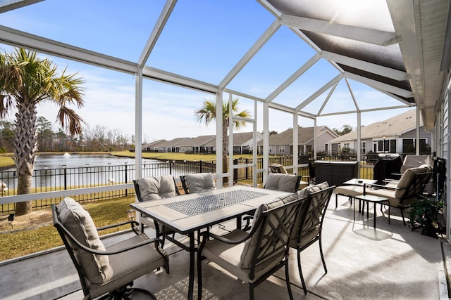 view of patio / terrace featuring a hot tub, a water view, and glass enclosure