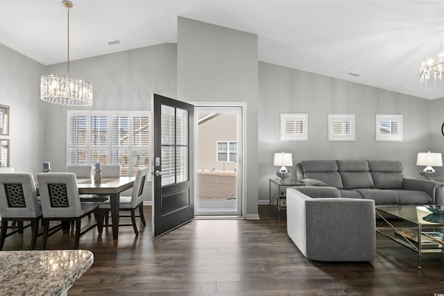 living room featuring dark wood-type flooring, a chandelier, and high vaulted ceiling