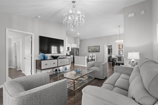 living room featuring dark hardwood / wood-style floors, a chandelier, and vaulted ceiling