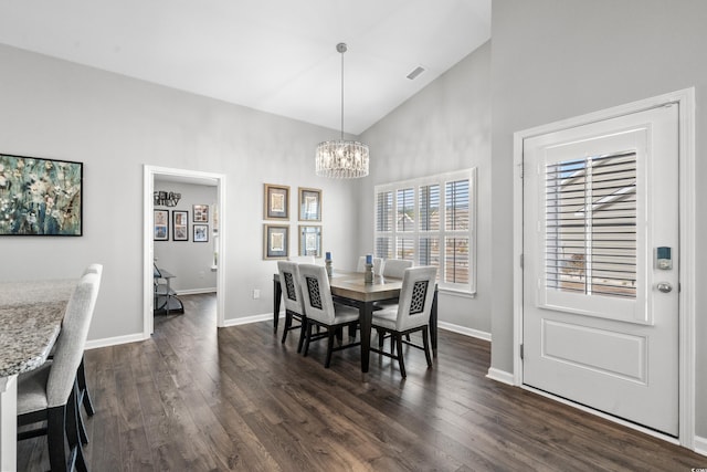 dining room featuring dark wood-type flooring, high vaulted ceiling, and a notable chandelier